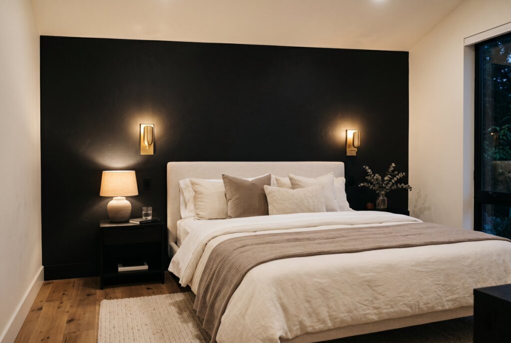 Black accent wall bedroom ideas with cream bedding and modern wall sconces.