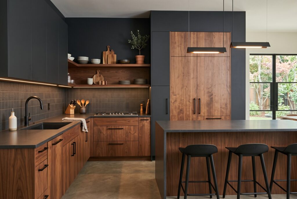 Modern dark wood kitchen with matte black cabinetry, sleek island, and ambient lighting.