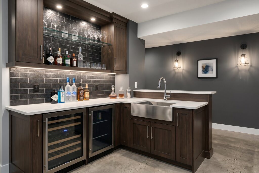 Wet bar with sink, beverage coolers, dark wood cabinets, and subway tile backsplash. 