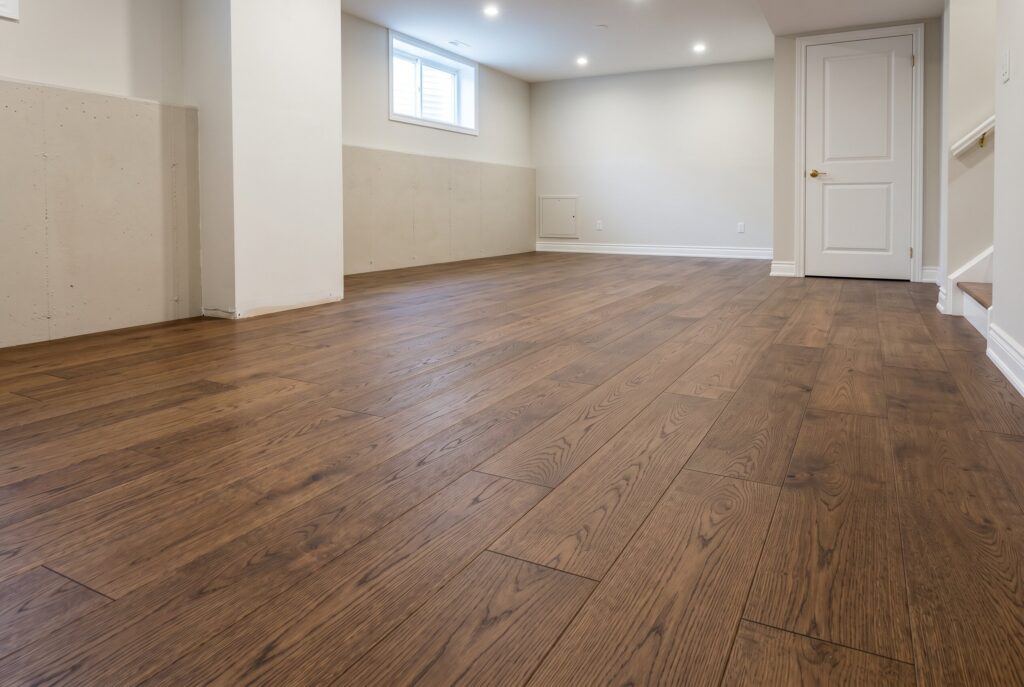 Engineered hardwood basement flooring with warm wood tones and finished family room layout.