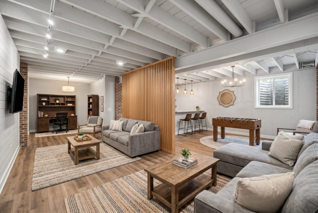 Open concept basement divided by wood slat partition with lounge and game zones.