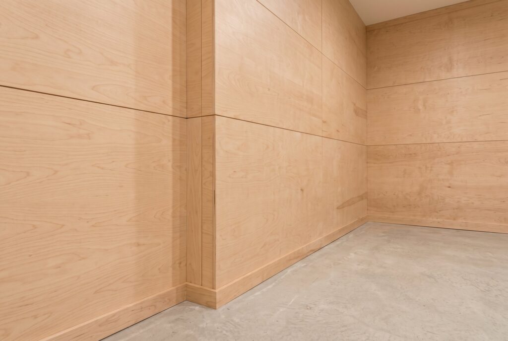 Birch plywood wall panels in unfinished basement with clean modern wood finish. 