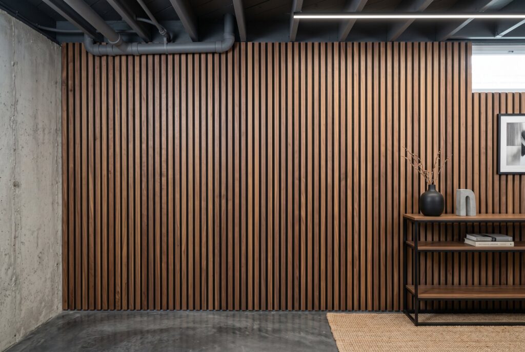 Walnut wood slat wall panels with black backing in modern Japandi basement. 