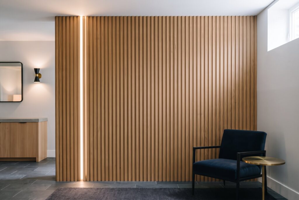 WPC wood look wall louvers with vertical texture in modern basement seating area.