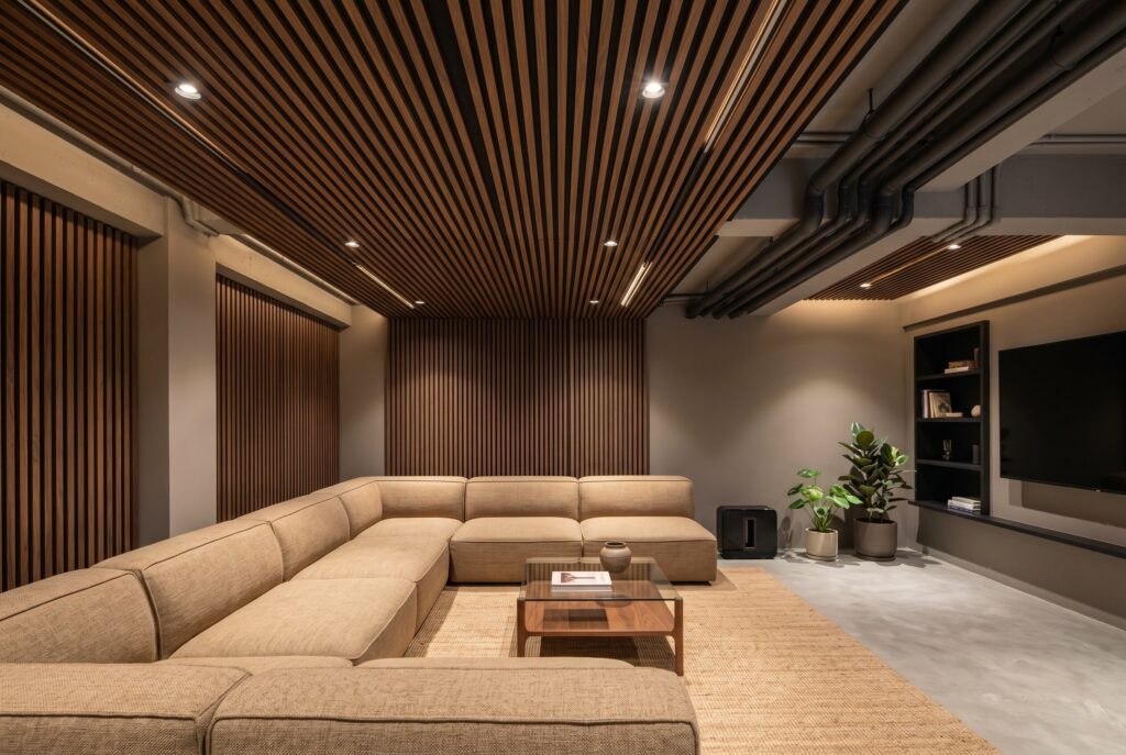 Acoustic wood slat ceiling panels with walnut finish in luxury basement media room.