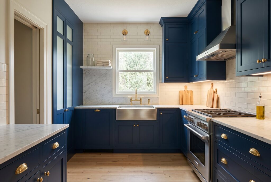 Deep navy closed kitchen with glass cabinets, cream tile, and under cabinet lighting.