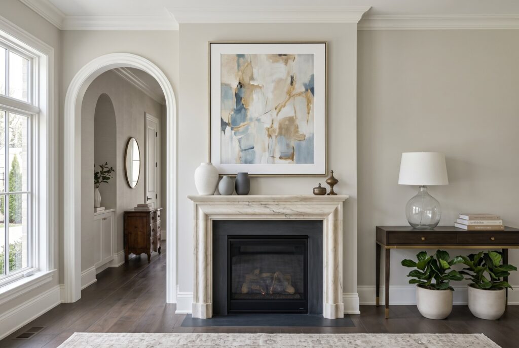 Transitional fireplace wall with large scale artwork and minimal decorative styling.