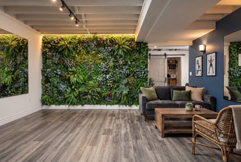 Faux greenery feature wall in windowless basement with workout equipment and seating area.