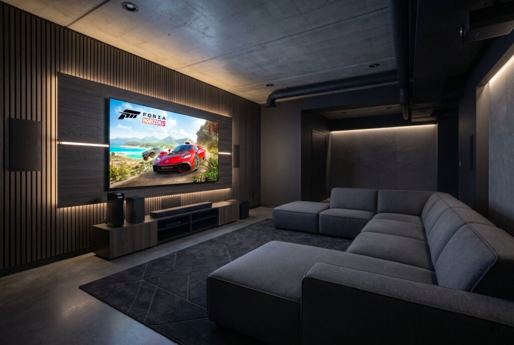 Console gaming theater with oversized screen, modular sectional, and integrated ambient lighting.