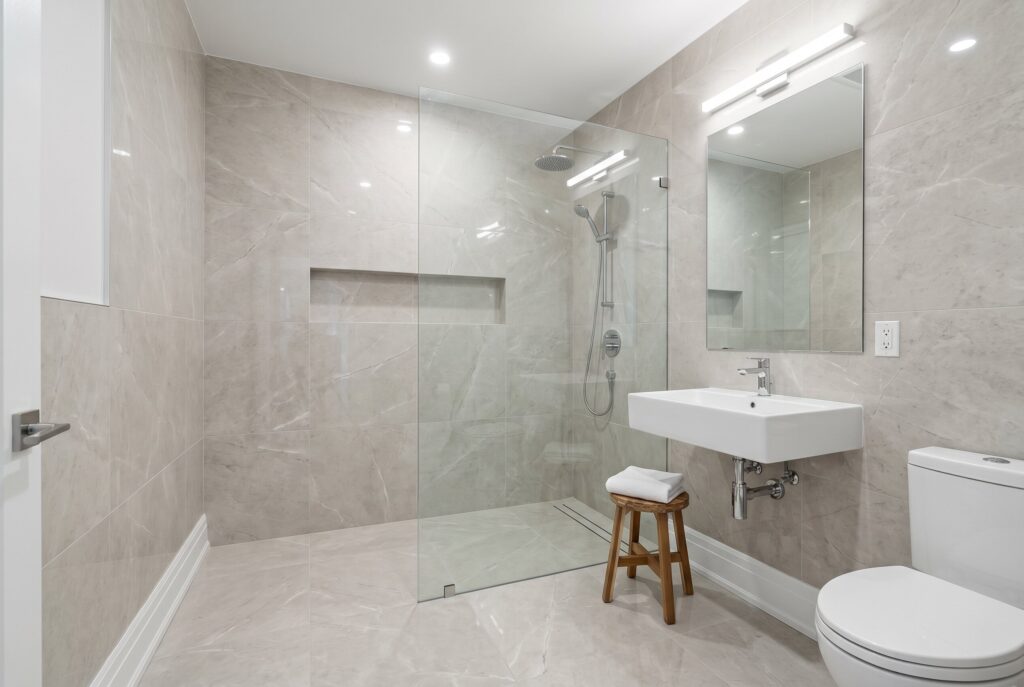 Floor to ceiling tile shower walls with large format porcelain tile and glass partition.