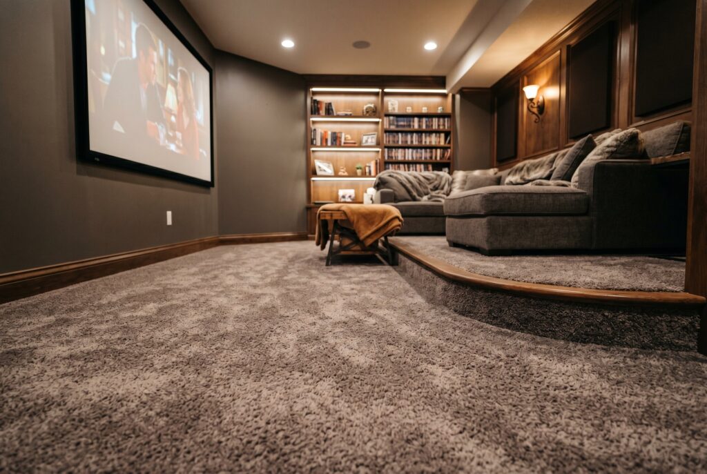 Carpet tile flooring in finished basement with neutral furnishings and modern design.