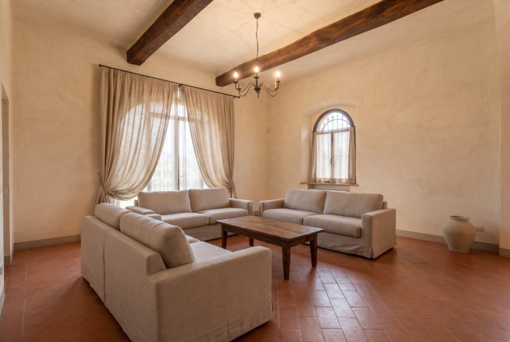Bright spacious living room with light slipcovered sofas on terracotta floors, replacing bulky dark leather furniture. 