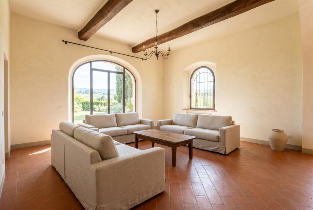 Bright spacious living room with light slipcovered sofas on terracotta floors, replacing bulky dark leather furniture.