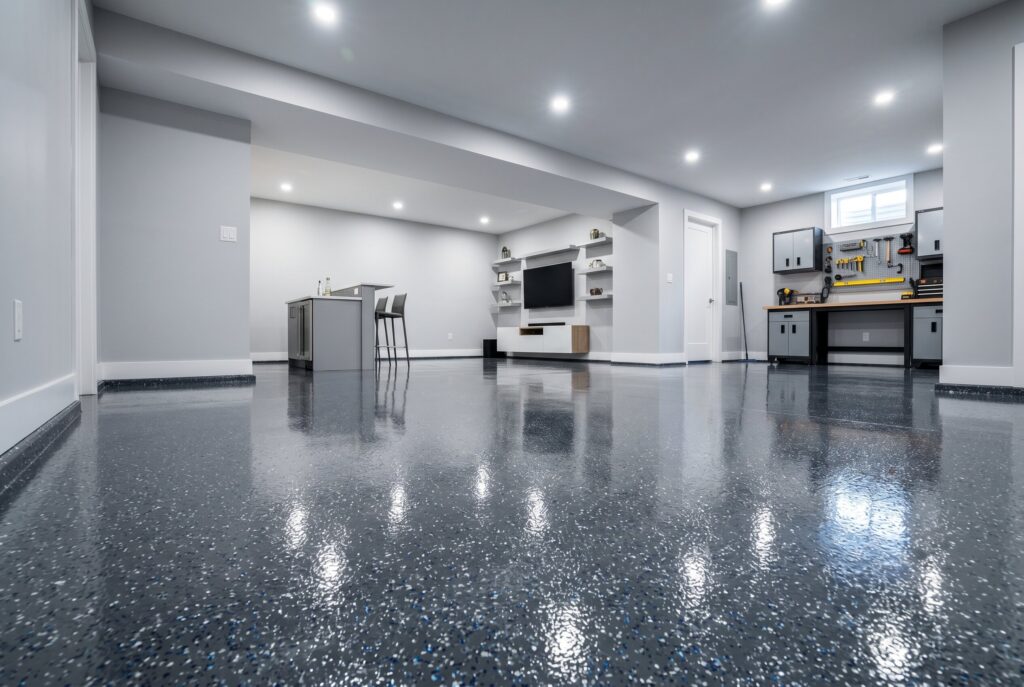 Glossy epoxy basement floor with entertainment zone, workshop area, and bright lighting.