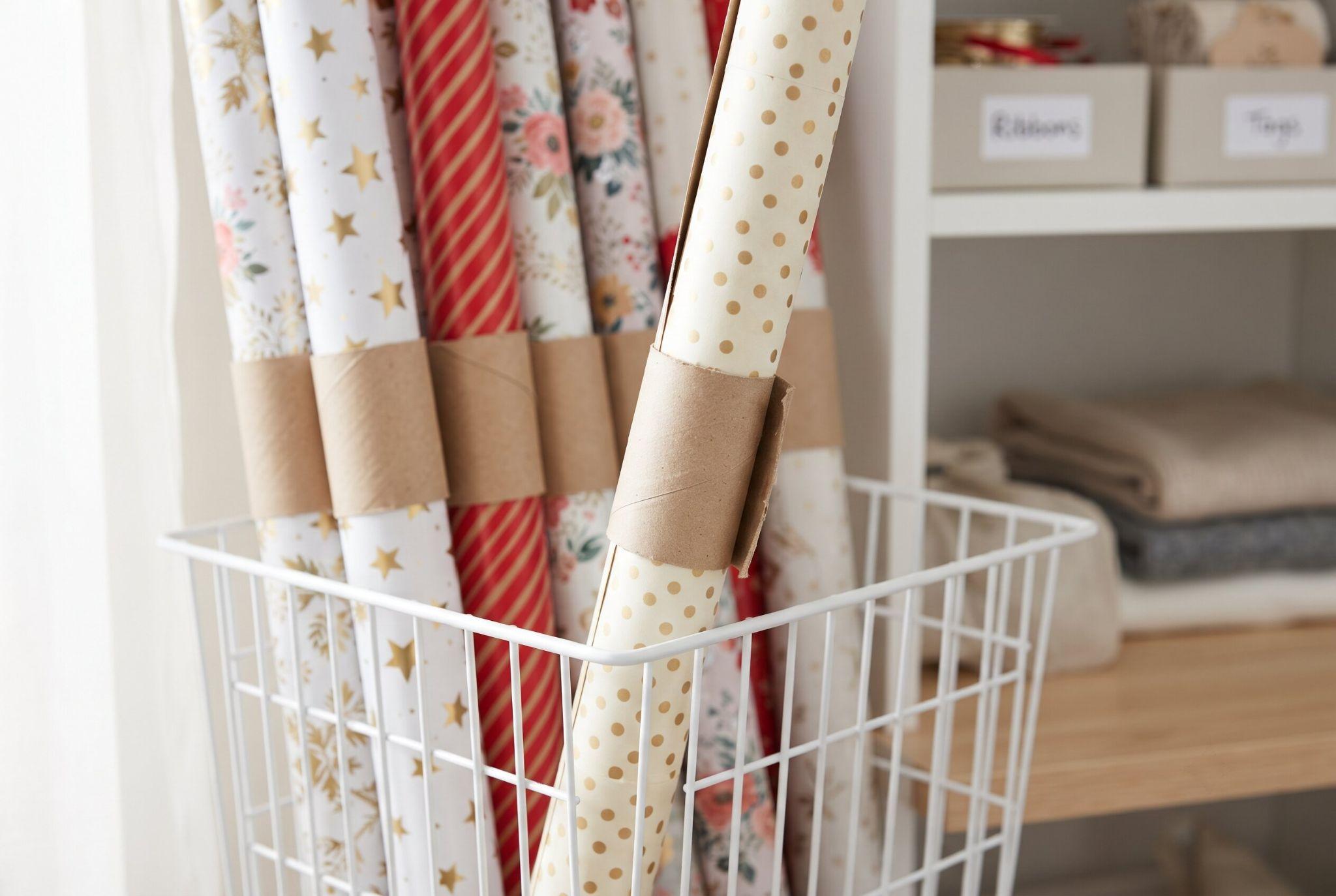 Wrapping paper rolls held together with DIY cardboard cuffs made from empty toilet paper tubes.