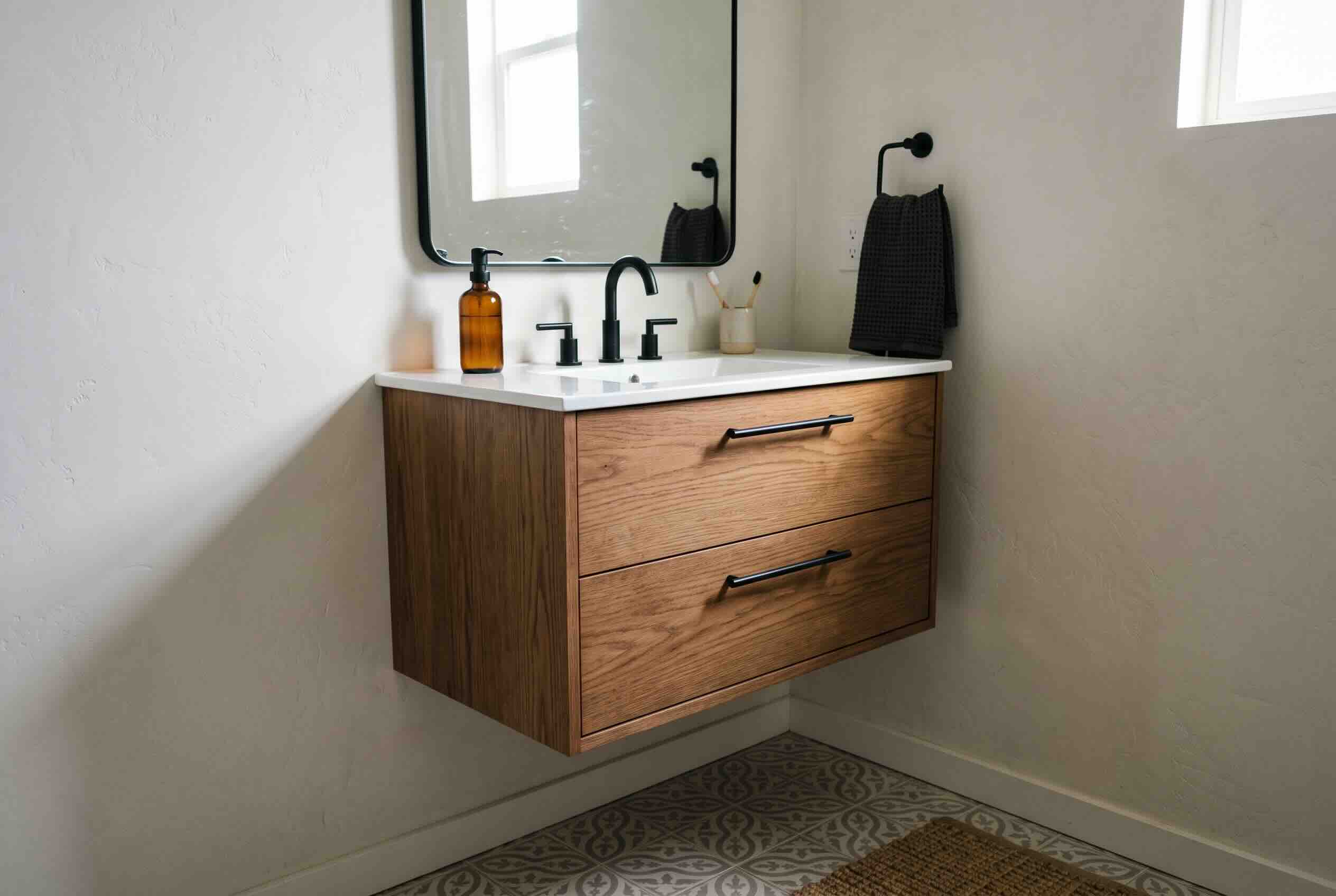 A wooden floating vanity mounted off the floor in a minimalist bathroom. 